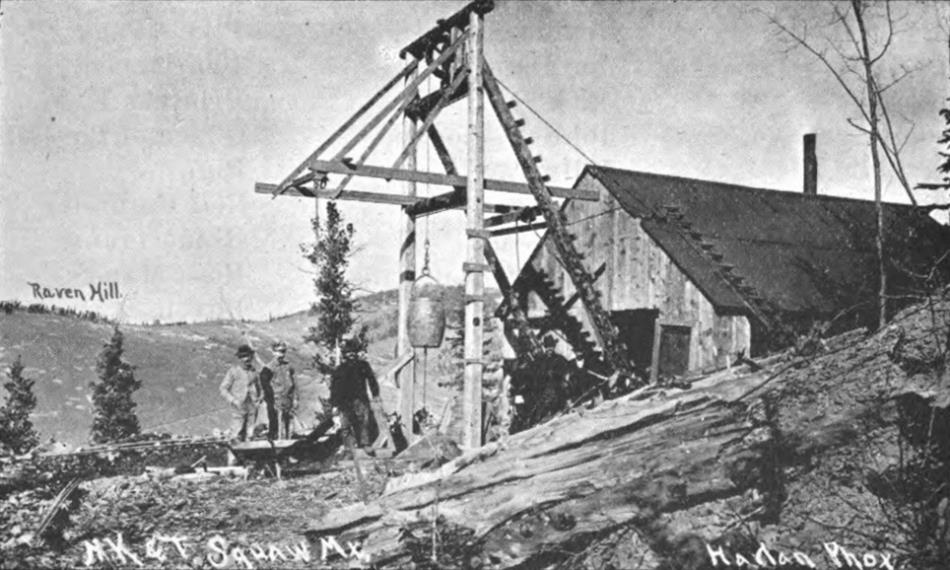 This is yet another of those early mine operations with a small head frame put in the open and a hoist house almost built into the frame work but still not covering the shaft from the elements. Raven Hill is seen in left background, while several people pose at the head frame in the foreground.