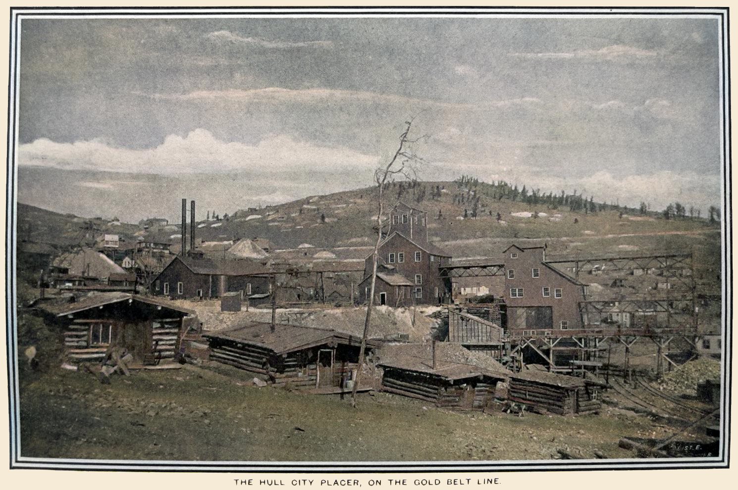This quite nice scene of the exterior of the Hull City Mine is lovely as it is an early view showing what must been recently made huge surface structures of this mine operations. In the foreground are a small row od log cabins, four in view. Behind those are the Hull City mine and in background is the south side of Bull Cliff or east Bull Hill as I also seen it named as. To the lower right the tracks of the railroads serving this mine are seen, both the Golden Circle and the Midland Terminal served the ore-bins. Making one of those tracks dual gauged.
   I did procure the colored version of this image. Source was grayish, or in common speech black & white. Used an online service and tweaked and worked with image to get what looks best to my eyes at the moment.