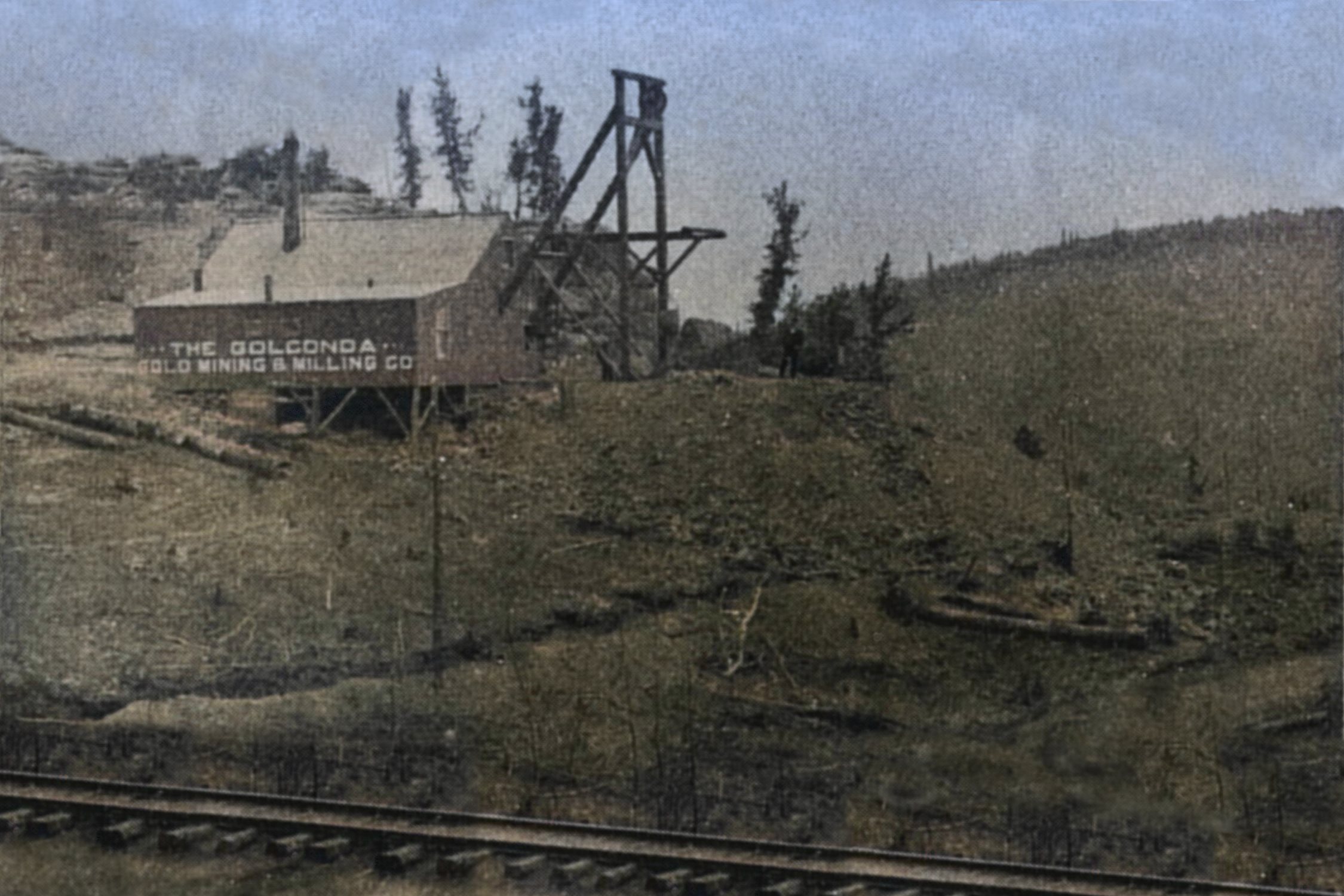 Sadly not a quality great view, but still a great view as it is a rare view from the trackside of the F. & C. C. mainline at the Golconda Mine Shaft no.1 operation on Squaw Mountain! The source is a group photo so the image sort of lacks details here and there, and I cheated a little on the colored version where I copied the tracks to fill out missing info at the lower right and left.
   Victor town is located outside the view at left, making the direction of the view in a southeast looking direction, and it appears like they have dug a trench just below the dump and the track, as there is a darker line there that might be a drainage drench for some reason but is more likely a left over from the early exploration of this ground.
   This shaft was located at the southern end of the claim, and sometime after 1896 it was abandoned, and the main working shaft moved further up the hill for some unknow reason. The structure and the headframe here are of somewhat large size so the hope and idea of this mine was certainly at this time around 1895-1896 looking prosperous! Being this was so visible from the train it is among those I need to try make a 3D model of some day!
   I did procure the colored version of this image as I think it is nicer. Source is gray-toned, or in common speech black & white. Used an online service and tweaked and worked with image to get what looks best to my eyes for the moment.