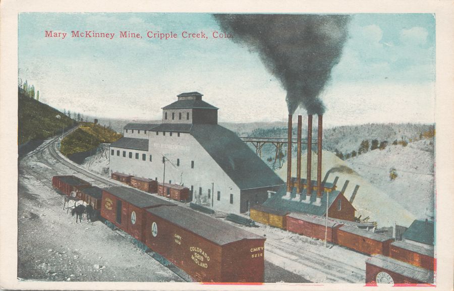 This image is showing the great Mary McKinney mine in Anaconda with lot of railroad traffic in front of. It shows the business side of the mine in terms of where the coal is brought in for power the mine, and where ore is taken away. Both in and out uses boxcars, the power plant is seen at lower right, with a string of boxcars in front of it. Further on another 3 boxcars are put up to load ore from the mine plant itself, along a spur that used to be dual gauged as both the M.T and the F. & C.C. used this spur to serve this mine. After the closing of the narrow gauge this spur was used to get access down to the El Paso mine way outside the view to the left. Town of Anaconda would have been down the valley at right. Also, in front left another side spur of the M.T. is used to load more boxcars with ore from surrounding mines on Guyot Hill via transfers from horse pulled ore-wagons – which would have been the way most of the mines did transport their ores to the railroads.