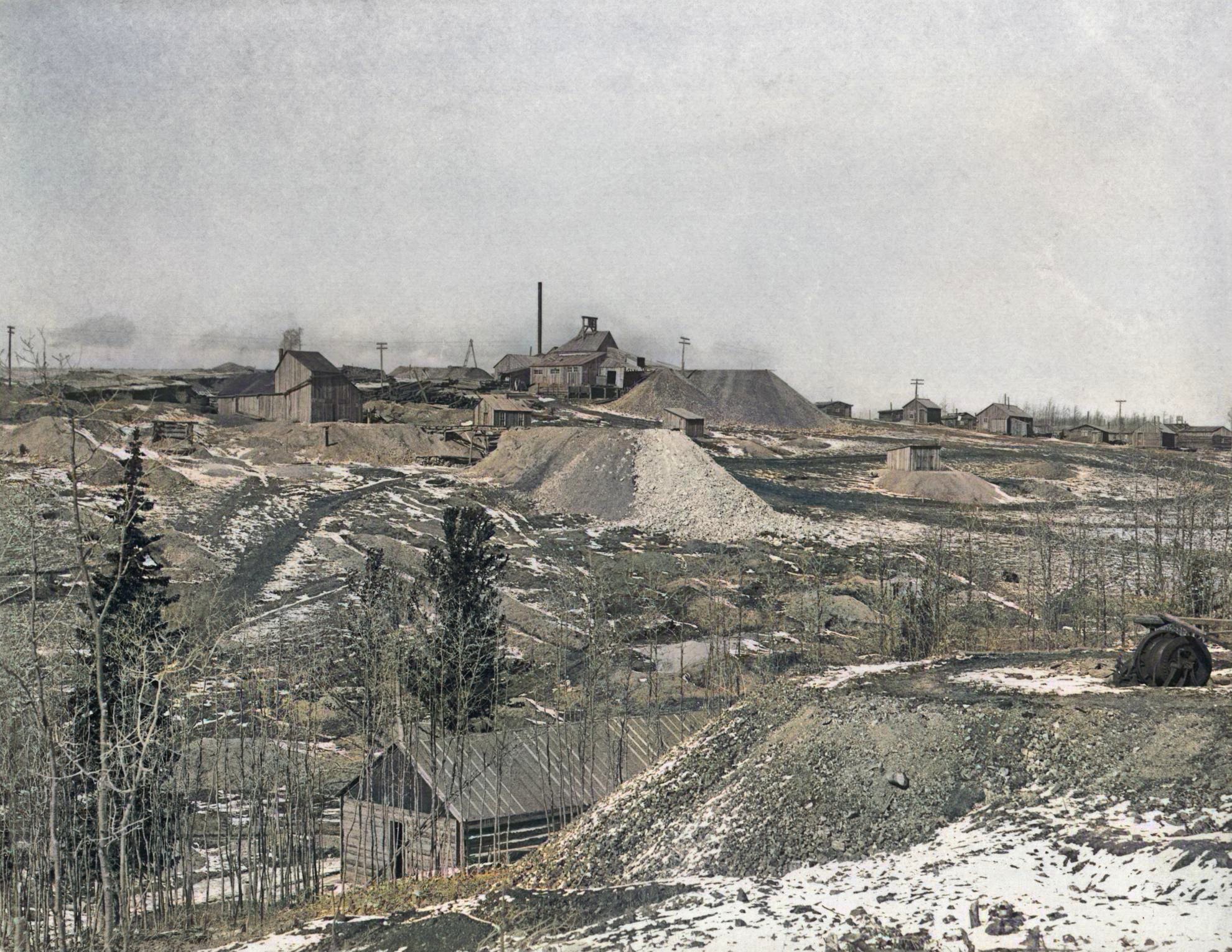    This DPL view (Call No. P-2014) are taken from Ironclad Hill, most likely in 1895 or early 1896. Wintertime as there are pieces of snow on the ground. It appears also in an 1896 book which helps date it somehow.
   In the foreground there is a longer Log based structure I feel is the same Deerhorn Mine Boarding House as I have in another picture in my collection (P-02433), while in the background is the top of Globe Hill with its small community called Summit in my 1903 USGS topographic map, and showing the Deerhorn and Summit Mines as per title in the 1896 book.
   About 1/3 down from top and the left most structure is the Shaft House of the Deer Horn, or Deerhorn mine, making then the one near center of the view the Summit mine operation, but which claim that is on is hard to tell as several claims belonging to the Summit Mining and Milling Company. To the right climbing the hill is the various Log and frame houses of miners and their families. In foreground right some mining machinery is seen on a dump that I think is one of the Plymouth Rock claims.
   I did procure the colored version of this image. Source was grayish, or in common speech black & white. Used an online service and tweaked and worked with image to get what looks best to my eyes at the moment.
