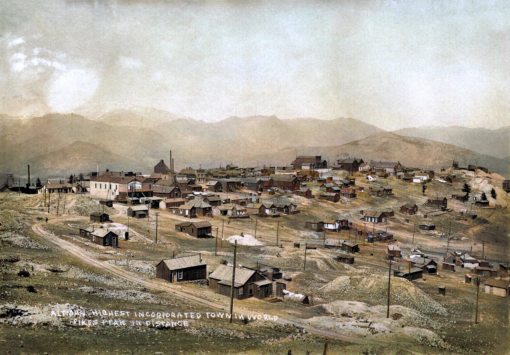 This is an enhanced view as source had flaws, a quite a bit faded, spots, discoloration, but I worked over it as best as I could. Town of Altman is seen from southwest, and the Burns Mine & head frame is visible at far left, at the edge of the image. The Shaft House of the Pinto Mine is also clearly seen where it is poking up behind the houses of Altman about 1/3 from the left. At right-hand side, about middle top/down is what I think is mining operation on the Wilson claim of the Free Coinage G.M. Co.
   I did procure the colored version of this image. Source was gray-toned, or in common speech black & white. Used an online service and tweaked and worked with image to get what looks best to my eyes for the moment.