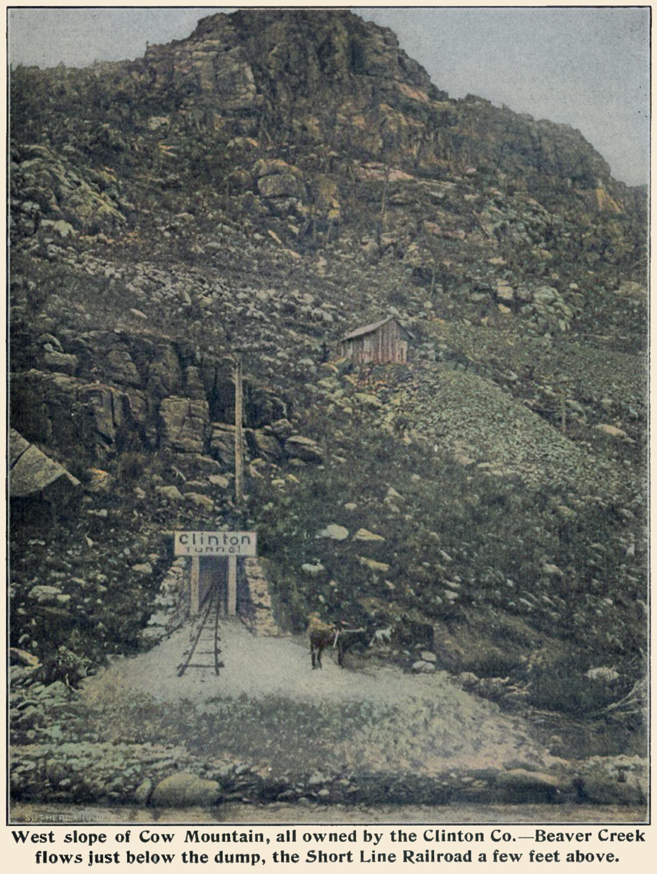 This view is sadly ''doctored'' somewhat, hence the keyword artistic, as the tunnel mouth is drawn into the image, clearly seen on the rail part that is not real looking at all. Sadly, as I feel the tunnel is really up there at the cabin halfway up the hillside with the Short Line grade seen further up the hill, about 1/3 down from the top.
   Not sure why they felt the need to draw in this so-called Clinton Tunnel in this view... What was shown in the source image there? I do not know, but when I compare this view with a Google Earth view I find an area that can look like this somewhat, and which is with a dump about where the structure sits quite same distance down from the old Short Line roadbed.
   Either way, this is a non-profitable mine, laying very much on the outside of the District, close to where the Short Line crosses over Beaver Creek and the railroad has its own route to/from the district after leaving the parallel run from about Cameron with the M.T. roadbed, where the M.T. goes around a hill and head north towards Gillett, and the Short Line heads east.
   I did procure the colored version of this image. Source was gray-toned, or in common speech black & white. Used an online service and tweaked and worked with image to get what looks best to my eyes for the moment.