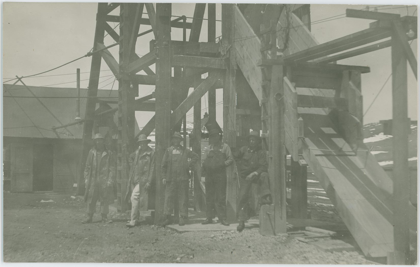 Another image I did not know where was at the time I bought it, but which I still wanted. And while I have this little bit uncertainty in me still, I do however strongly feel that this is at the Cameron Mine, where 5 men are posing for the photographer, standing in front of a Head-Frame, with the Hoist-House and shed type of structure in background left and a chute down from the Head-Frame in front right. I've seen a marked postcard with the same head-frame and hoist-house look as here, hence the strong feel this being the Cameron Mine, located in Cameron/Grassy Valley in the District.
