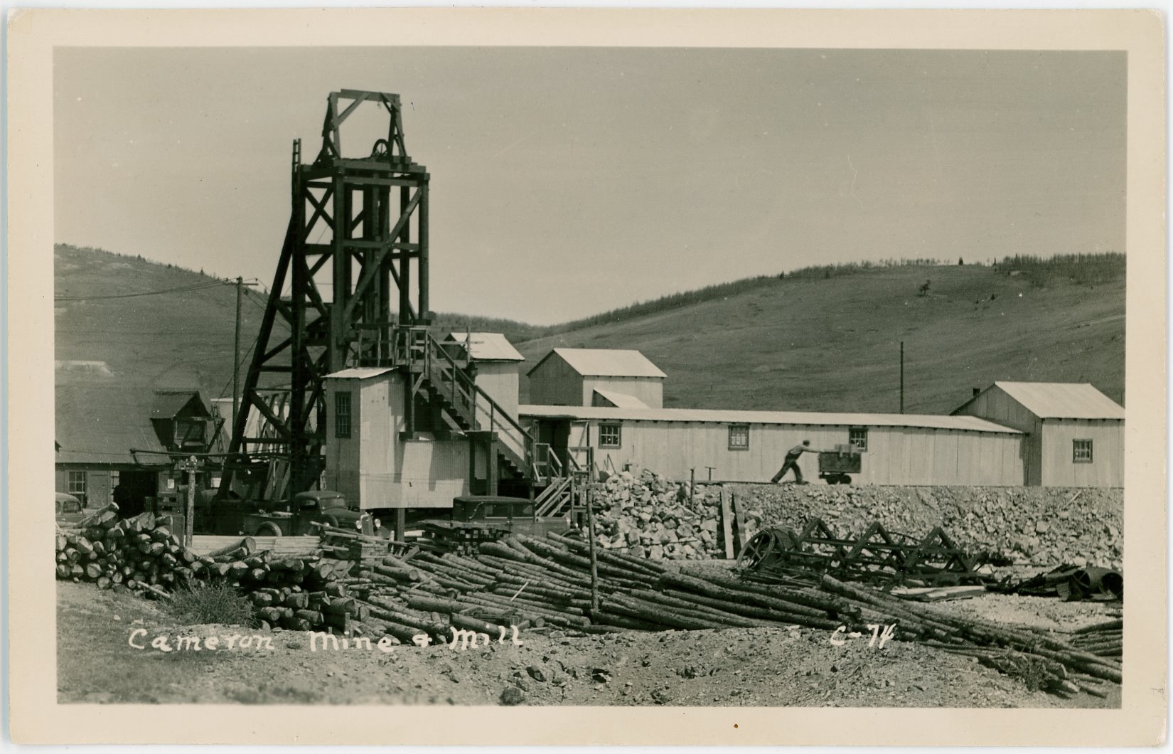 I assume this Cameron Mine is the same Cameron mine that I have read was controlled by the Woods Investment Co. in 1901 and which property the Cameron Gold Mines, Inc., produced from 1935 through June 1942, when operations ceased. Golden Cycle acquired the property in 1944, and although intermittently operated through the late 1940's, it became a principal shipper for Golden Cycle.
   Image shows a postcard that has a stamp-box mark that fits the 1926 till 1940 timeframe so 1930's fits, not being an automobile person though, the cars don't help me date anything.
   I think this view is looking north, northwest, with part of Galena Hill at left.